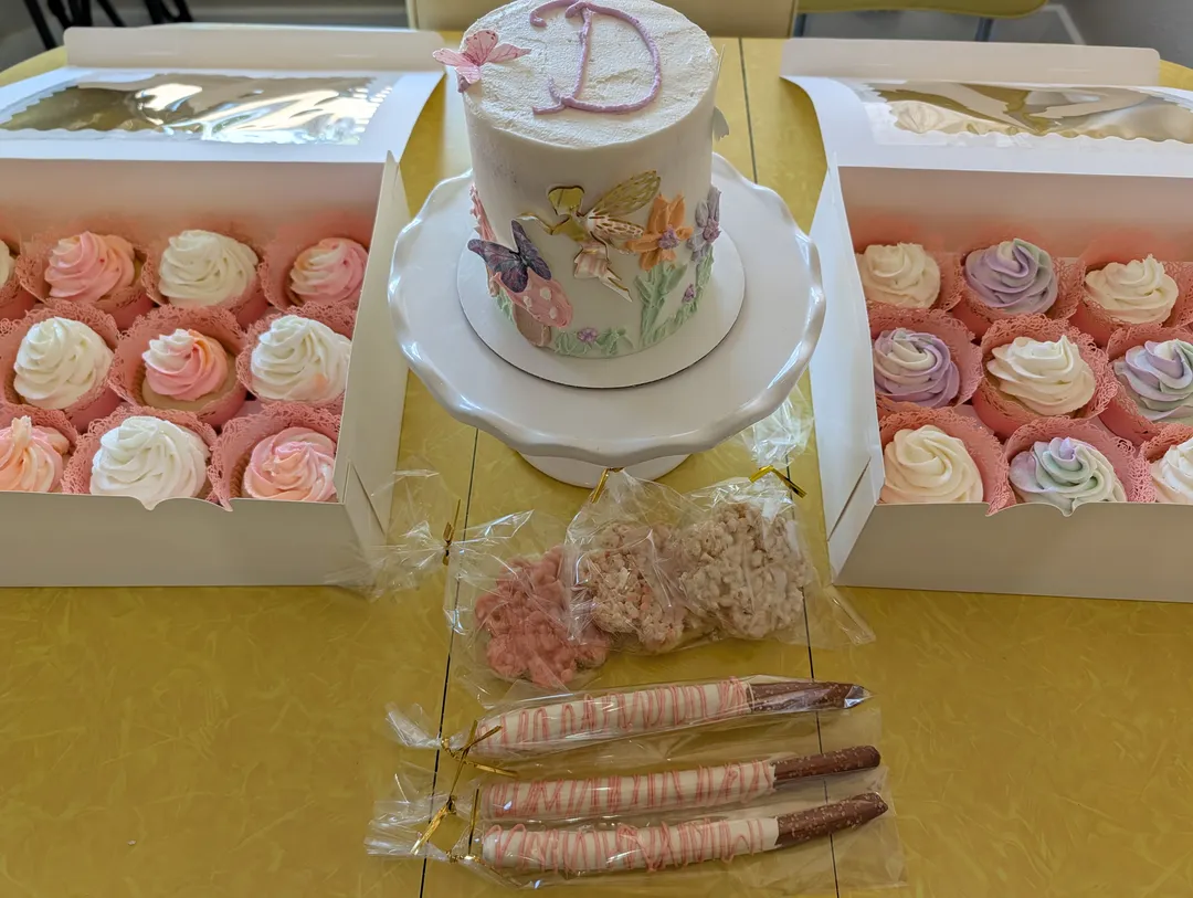 Coordinating smash cake, cupcakes, dipped pretzels, and dipped rice crispy treats